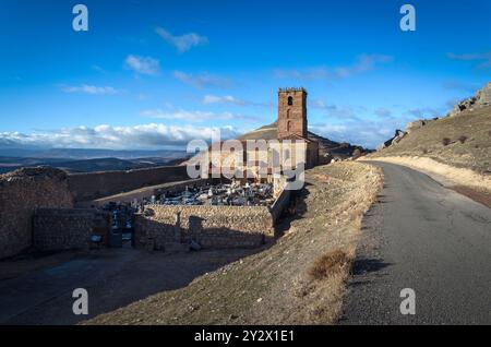 Die Kirche Santa Maria del Rey mit dem annektierten Friedhof an einem blauen Tag mit Wolken, Atienza, Guadalajara, Spanien Stockfoto