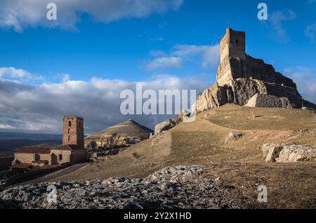 Schloss Atienza auf der Spitze des Hügels und die Kirche Santa María del Rey an einem blauen Himmel mit Wolken, Guadalajara, Spanien Stockfoto