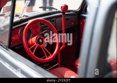 Detail des Innenraums eines Volkswagen Typ 1 oder auch bekannt als Käfer im Hotrod-Stil. Rotes Lenkrad und hoher Schalthebel mit Schädel Stockfoto