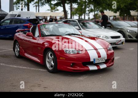 Klassisches japanisches Cabriolet, zweisitziger Sportwagen, der getunte Mazda MX-5 (Miata) NB der zweiten Generation. Er ist rot mit weißen Linien und Masken Stockfoto