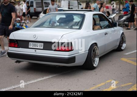 Rückansicht eines spektakulären weißen Mercedes Benz C124 Coupés, ein klassischer deutscher Luxus-Sportwagen, der mit großen und verchromten Rädern restauriert wurde Stockfoto