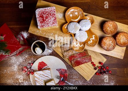 Die Feiertagsdesserts einschließlich Kuchen, Kekse, Muffins und eine Tasse Kaffee auf dem Tisch. Stockfoto