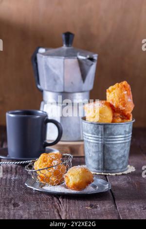 Quark Donuts mit Zucker serviert mit Tee oder Kaffee auf hellem Holzhintergrund. Rustikaler Stil. Stockfoto