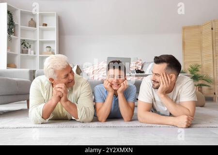 Teenager mit Vater und Großvater, die zu Hause auf dem Boden liegen Stockfoto