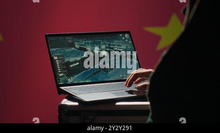 Chinesischer Soldat im Kontrollraum, der Militärtechnologie benutzt, um Bedrohungen von Feinden zu identifizieren. Militärangehörige benutzen Software auf dem Laptop, um Informationen an Generäle an der Kriegsfront zu übermitteln, Kamera A Stockfoto