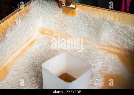Ein Schuss einer Bürstlösung durch Glasfaserplatten auf einer Holzkiste. Stockfoto