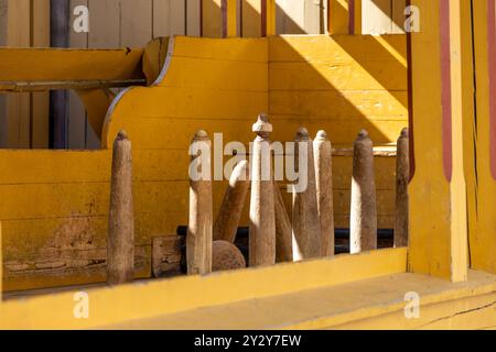 Aus nächster Nähe eine Holzversion des Bowlingsports mit einer Mischung aus Texturen und Schatten. Die Szene fängt rustikale Elemente mit einem verspielten Design ein. Stockfoto