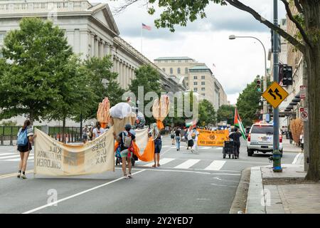 Washington DC, USA - 19.08.2024: Eine Gruppe von Menschen marschiert die Straße hinunter und hält Schilder mit der Aufschrift: "Israel benutzt U STEUER, um palästinensisches Kind zu töten Stockfoto