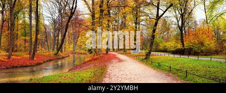 Herbstlandschaft, Banner, Panorama - Blick auf einen Herbstpark mit Bachlauf und Parkwegen, im Englischen Garten befindet sich ein öffentlicher Park in München, Bavari Stockfoto