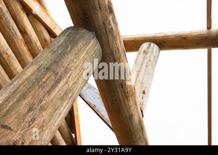 Ländliches Holzhaus aus Baumstämmen ist im Bau, Nahaufnahme von Holzteilen unter hellem Himmel Stockfoto