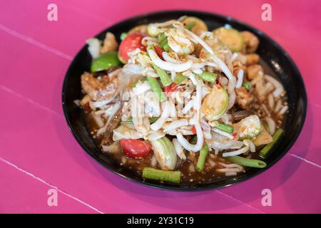 Scharfer Salat, der bunt und lecker ist, mit eingelegtem Fisch, langen Bohnen, Sojasprossen, Schweineschalen, knuspriger Fisch, Tomaten und Pfeffer. Bereit, auf Woo zu essen Stockfoto