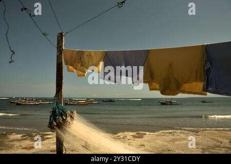 Wäscherei- und Fischernetz im Hintergrund von Fischerbooten und Indischem Ozean, fotografiert am Malabero (Malabro) Strand in Bengkulu, Indonesien. Stockfoto