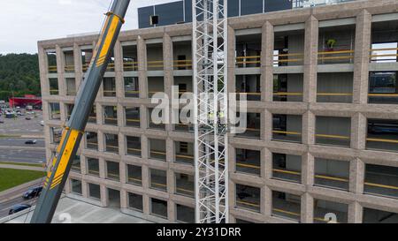 Luftaufnahme einer Baustelle mit Kränen, Baufahrzeugen und Baumaterialien. Bauarbeiter, die große Krane mit sma entfernen Stockfoto