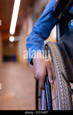 Rollstuhl benutzen, afroamerikanisches Mädchen im Schulflur, Handgriff für Mobilität Stockfoto