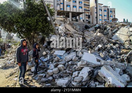 Gaza, Palästina, 26. März 2019. Die Palästinenser bewerten die Schäden am Standort des Multazim-Versicherungsgebäudes, das am 25. März durch israelische Bombardements im Osten von Gaza-Stadt zerstört wurde. Israelische Kampfflugzeuge führten Dutzende von Luftangriffen im südlichen, mittleren und nördlichen Gazastreifen durch, nachdem eine Gaza-Rakete ein israelisches Haus nördlich von Tel Aviv in Zentralisrael getroffen hatte und sieben Israelis verletzt hatte. Israelische Kampfflugzeuge zielten auf Standorte der Hamas sowie Dutzende Wohn- und Geschäftsgebäude ab, und laut dem palästinensischen Gesundheitsministerium in Gaza leiden sieben Palästinenser Stockfoto