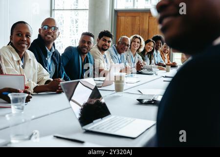 Verschiedene Kollegen, die lächeln und an einem Business Panel-Meeting im Büro teilnehmen, um Teamarbeit und Zusammenarbeit zu vertreten. Stockfoto