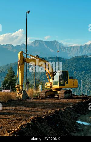 Ein schwerer Bagger arbeitet in den Bergen Stockfoto