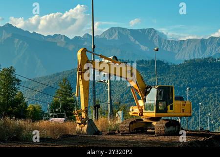 Ein schwerer Bagger arbeitet in den Bergen Stockfoto