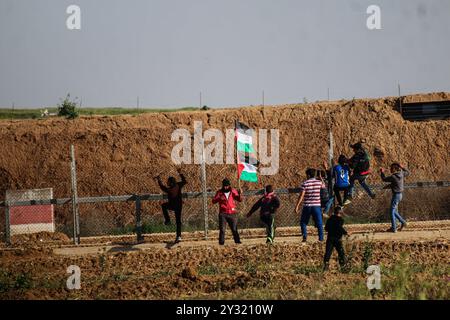 Gaza, Palästina, 12. April 2019. Palästinenser stoßen an diesem Freitag in Abu Safiya östlich der Stadt Jabaliya im nördlichen Gazastreifen auf die israelische Armee. Die 15-jährige palästinensische Maysara Abu Shaloof wurde getötet, nachdem sie von lebenden israelischen Schüssen in den Magen geschossen wurde, während dreißig weitere Palästinenser während der Proteste und Zusammenstöße an mehreren Stellen entlang der Grenze zwischen Gaza und Israel am Freitag verletzt wurden. Etwa 6.000 Demonstranten nahmen an den Grenzkundgebungen Teil, und während einige Palästinenser Steine in Richtung Zaun und israelische Armee warfen, warfen israelische Soldaten Stockfoto