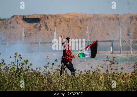 Gaza, Palästina, 12. April 2019. Palästinenser stoßen an diesem Freitag in Abu Safiya östlich der Stadt Jabaliya im nördlichen Gazastreifen auf die israelische Armee. Die 15-jährige palästinensische Maysara Abu Shaloof wurde getötet, nachdem sie von lebenden israelischen Schüssen in den Magen geschossen wurde, während dreißig weitere Palästinenser während der Proteste und Zusammenstöße an mehreren Stellen entlang der Grenze zwischen Gaza und Israel am Freitag verletzt wurden. Etwa 6.000 Demonstranten nahmen an den Grenzkundgebungen Teil, und während einige Palästinenser Steine in Richtung Zaun und israelische Armee warfen, warfen israelische Soldaten Stockfoto