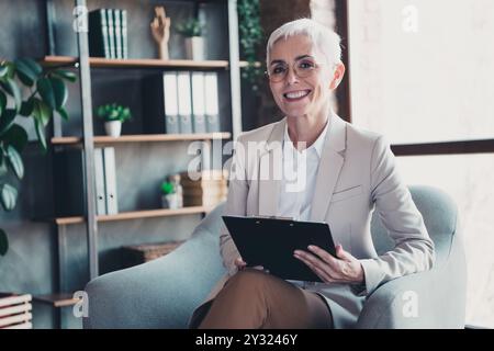 Foto von Psychotherapeutin Büro Reife Frau Sessel Psychologin berät Beziehungsprobleme Familienleben modernes Büro Innenraum Stockfoto