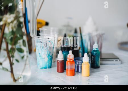 Lebendige Epoxidharzkunst mit verschiedenen Pigmenten und Werkzeugen in einem DIY-Arbeitsbereich Stockfoto