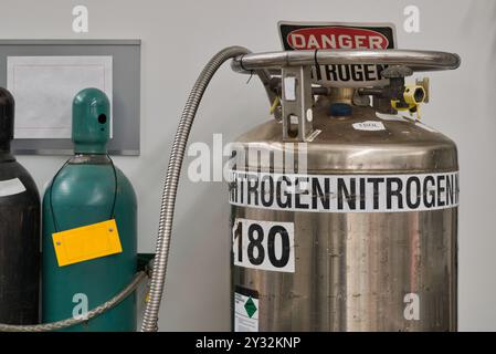 Stickstoffbehälterzylinder, industrielles wissenschaftliches Labor, das Gefahrenzeichen setzt. Stockfoto