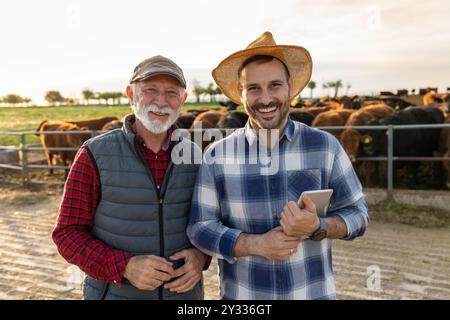 Porträt von zwei Bauern, Vater und Sohn, vor Rindern auf der Ranch Stockfoto