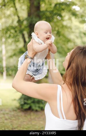 Eine Frau hält ein Baby in den Armen in einem Park Stockfoto