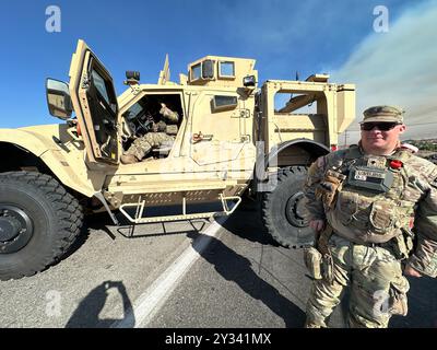 Phelan, CA, USA. September 2024. Die US National Guard 330 Unit und die Polizei bewachen den Eingang zum Highway 138 (Beekley Rd), der geschlossen wird, um Menschen vom Skigebiet Wright Wood fernzuhalten. Rauch aus dem Bridge Fire im Angeles National Forest, aus der Wüste direkt am Pear Blossom Highway, zwischen Llano und Phelan, Kalifornien. (Kreditbild: © Amy Katz/ZUMA Press Wire) NUR REDAKTIONELLE VERWENDUNG! Nicht für kommerzielle ZWECKE! Stockfoto