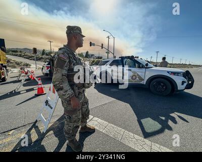 Phelan, CA, USA. September 2024. Die US National Guard 330 Unit und die Polizei bewachen den Eingang zum Highway 138 (Beekley Rd), der geschlossen wird, um Menschen vom Skigebiet Wright Wood fernzuhalten. Rauch aus dem Bridge Fire im Angeles National Forest, aus der Wüste direkt am Pear Blossom Highway, zwischen Llano und Phelan, Kalifornien. (Kreditbild: © Amy Katz/ZUMA Press Wire) NUR REDAKTIONELLE VERWENDUNG! Nicht für kommerzielle ZWECKE! Stockfoto