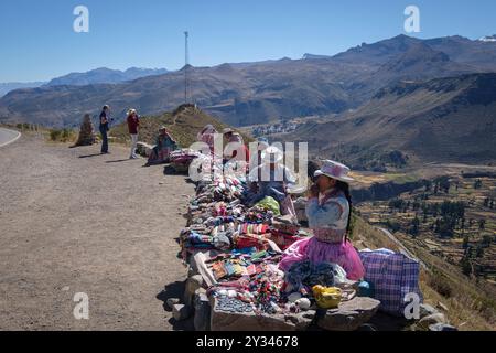 Ein Marktstand am Straßenrand in der Andenaltiplano, Peru, wo Stoffe, Schals, Handschuhe und Hüte verkauft werden. Die Stallbesitzer sind erwachsene Frauen in der Tradition Peruvi Stockfoto