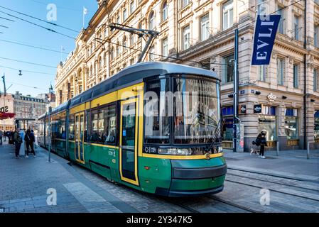 Helsinki, Finnland. 4. Mai 2024: Grüne Straßenbahn, die Menschen an einem schönen Frühlingstag in Finnland im Zentrum der Stadt Helsinki transportiert Stockfoto