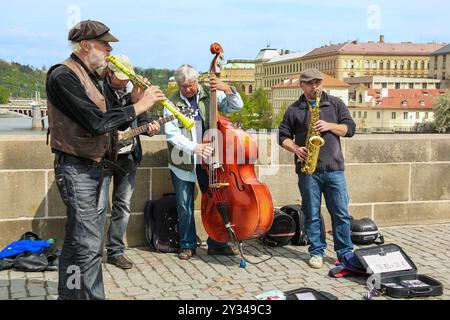 PRAG, TSCHECHISCH - 24. APRIL 2012: Nicht identifizierte Straßenmusiker spielen für die Öffentlichkeit auf der Karlsbrücke. Stockfoto