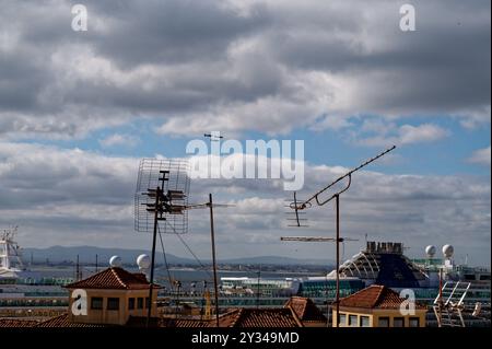 Inmitten veralteter Dächer und Fernsehantennen schneiden sich elegante Kampfflugzeuge durch den weiten Himmel Stockfoto