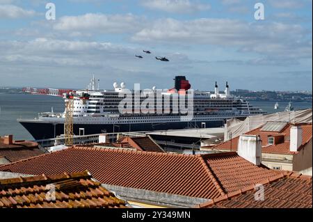 Ein großes Kreuzfahrtschiff dominiert die Uferpromenade, während Hubschrauber über die Terrakotta-Dächer von Alfama fliegen Stockfoto