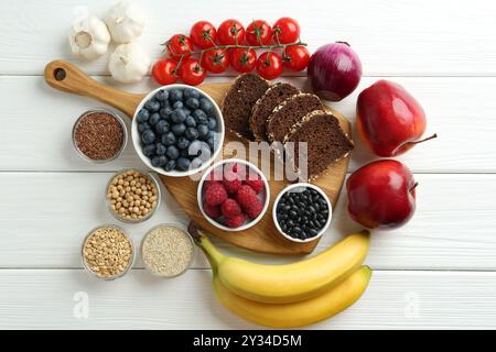 Verschiedene frische Produkte auf weißem Holztisch, flach gelegt. Quelle der Präbiotika Stockfoto