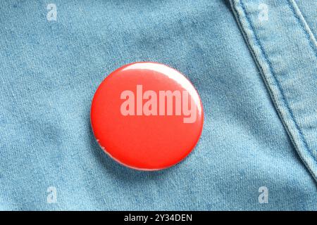 Rotes Knopfabzeichen auf dem Jeansshirt, Ansicht von oben. Modell für Design Stockfoto