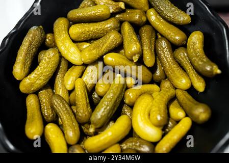 Viele kleine eingelegte Gurken in einer Schüssel. Stockfoto