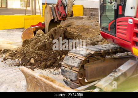 Baggerlöffel sammelt Erde und alten Asphalt auf einer Baustelle Stockfoto