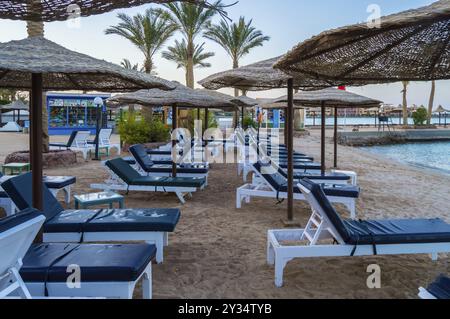 Reihen von Liegestühlen und Sonnenschirmen am Strand in der Stadt von Hurghada in Ägypten Stockfoto