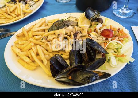 Meeresfrüchte-Platte mit Pommes Frites und kleines Gemüse in Malta Stockfoto