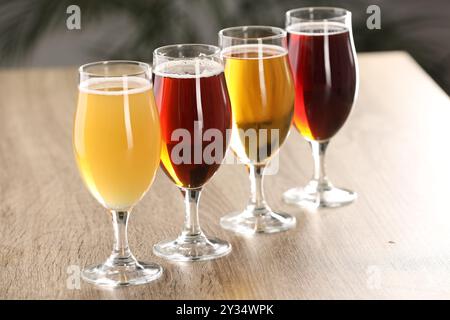 Gläser mit verschiedenen Biersorten auf Holztisch drinnen Stockfoto