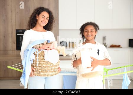 Afroamerikanische Frau und ihre Tochter mit Wäsche zu Hause Stockfoto