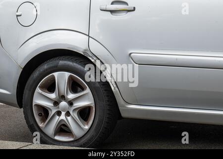 Verbeulte und zerkratzte Karosserie des Radkastens. Allgemeines Auto, Vorderansicht, keine Personen. Stockfoto