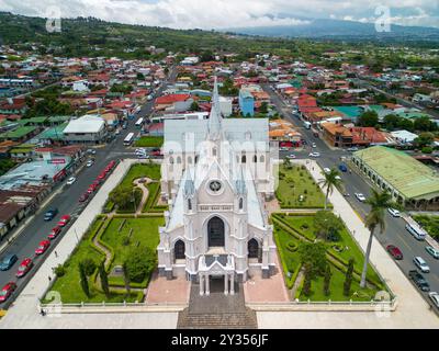 Ein Blick aus der Vogelperspektive von Parroquia San Rafael Arcangel in Costa Rica mit der umliegenden Stadt und üppigem Grün Stockfoto
