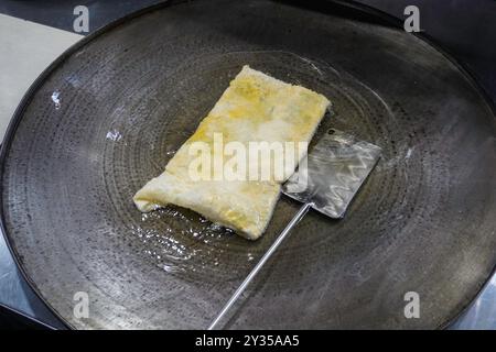 Braten von Martabak Telor oder Omelett-Marttabak in heißem Öl. Herzhaftes, gebratenes Gebäck mit Ei, Fleisch und Gewürzen. Traditionelle Snacks von Indones Stockfoto