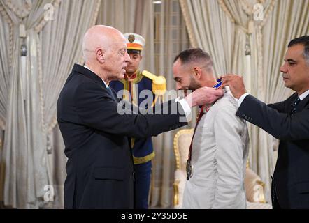 Der tunesische Präsident Kais Saied ehrt den Meister Rawaa Tlili, der bei den Paralympischen Spielen in Paris 2024 eine Goldmedaille im Kugelstoßen und eine Goldmedaille im Diskuswurf gewann, sowie den Champion Walid Ktila, der im 100-m-Rollstuhl eine Silbermedaille gewann. Der tunesische Präsident von Karthago, Kais Saied, ehrt den Meister Rawaa Tlili, der bei den Paralympischen Spielen in Paris 2024 eine Goldmedaille im Kugelstoßen und eine Goldmedaille im Diskuswurf gewann, und ehrt auch den Champion Walid Ktila, der im 100-m-Rollstuhl eine Silbermedaille gewann. Carthage Palace, Tunis, am 11. September 2024. Foto: Tunesischer Ratsvorsitz apaimages Tunis Tunis Tu Stockfoto