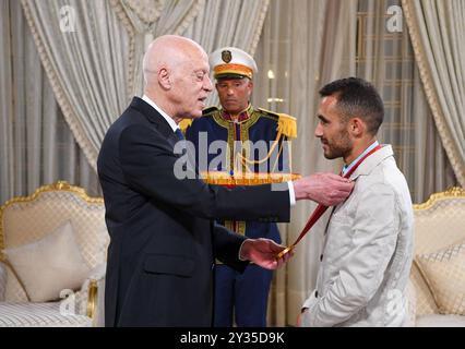 Der tunesische Präsident Kais Saied ehrt den Meister Rawaa Tlili, der bei den Paralympischen Spielen in Paris 2024 eine Goldmedaille im Kugelstoßen und eine Goldmedaille im Diskuswurf gewann, sowie den Champion Walid Ktila, der im 100-m-Rollstuhl eine Silbermedaille gewann. Der tunesische Präsident von Karthago, Kais Saied, ehrt den Meister Rawaa Tlili, der bei den Paralympischen Spielen in Paris 2024 eine Goldmedaille im Kugelstoßen und eine Goldmedaille im Diskuswurf gewann, und ehrt auch den Champion Walid Ktila, der im 100-m-Rollstuhl eine Silbermedaille gewann. Carthage Palace, Tunis, am 11. September 2024. Foto: Tunesischer Ratsvorsitz apaimages Tunis Tunis Tu Stockfoto