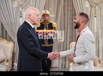 Der tunesische Präsident Kais Saied ehrt den Meister Rawaa Tlili, der bei den Paralympischen Spielen in Paris 2024 eine Goldmedaille im Kugelstoßen und eine Goldmedaille im Diskuswurf gewann, sowie den Champion Walid Ktila, der im 100-m-Rollstuhl eine Silbermedaille gewann. Der tunesische Präsident von Karthago, Kais Saied, ehrt den Meister Rawaa Tlili, der bei den Paralympischen Spielen in Paris 2024 eine Goldmedaille im Kugelstoßen und eine Goldmedaille im Diskuswurf gewann, und ehrt auch den Champion Walid Ktila, der im 100-m-Rollstuhl eine Silbermedaille gewann. Carthage Palace, Tunis, am 11. September 2024. Foto: Tunesischer Ratsvorsitz apaimages Tunis Tunis Tu Stockfoto